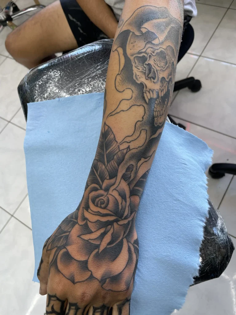 Half sleeve skull and flower tattoo by Kawika